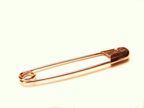 A silver safety pin on a white background