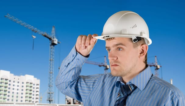 Engineer at white helmet on building background