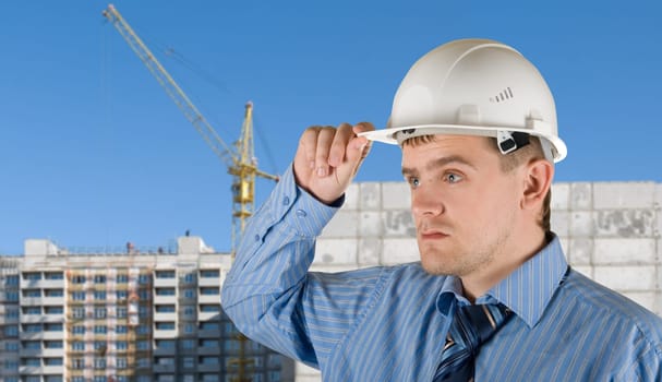 Engineer at white helmet on building background