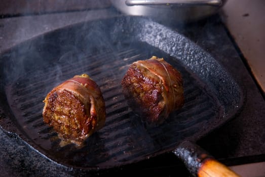 Tasty beef steak grilling in a cast-iron ribbed fry pan