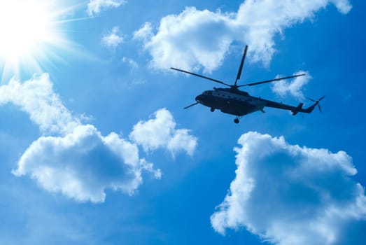 helicopter is flying in blue sunny sky