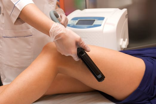 Laser epilation of leg in a modern beauty shop
