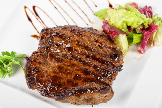 Roasted beef steak with vegetable closeup at plate