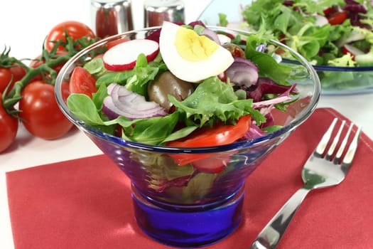 a blue glass bowl with mixed salad