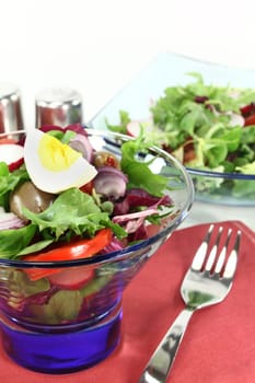 a blue glass bowl with mixed salad