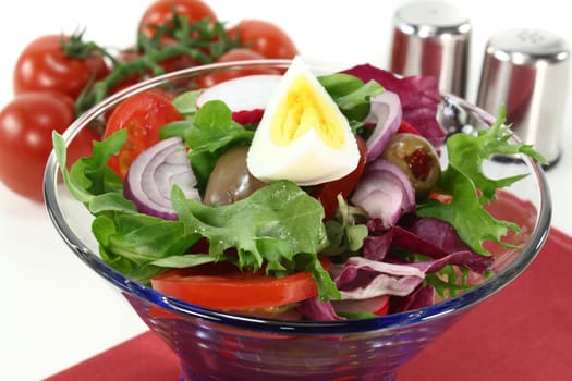 a blue glass bowl with mixed salad