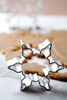 Making gingerbread cookies for Christmas. Gingerbread dough with star shapes and a cutter.
