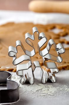 Making gingerbread cookies for Christmas. Gingerbread dough with star shapes and a snowflake cutter.