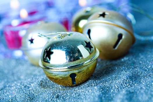 Close-up of golden jingle bell Christmas baubles with candles