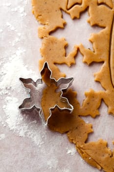 Making gingerbread cookies for Christmas. Gingerbread dough with star shapes and a cutter.