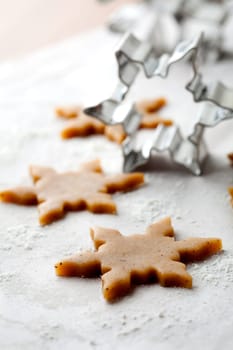 Making gingerbread cookies for Christmas. Gingerbread dough with star shapes and a cutter.