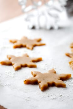 Making gingerbread cookies for Christmas. Gingerbread dough with star shapes and a cutter.