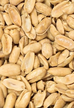 Detailed closeup of salted peanuts. The nuts fill the entire frame in portrait format.