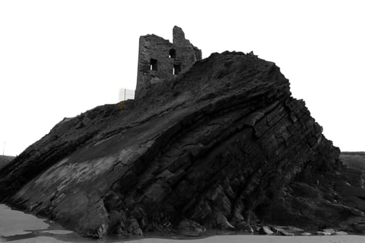 black and white image of ballybunion castle on the rocks in the west coast of ireland