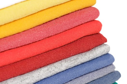 Stack of colored tee shirts on a shelf