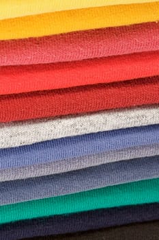 Stack of colored tee shirts on a shelf