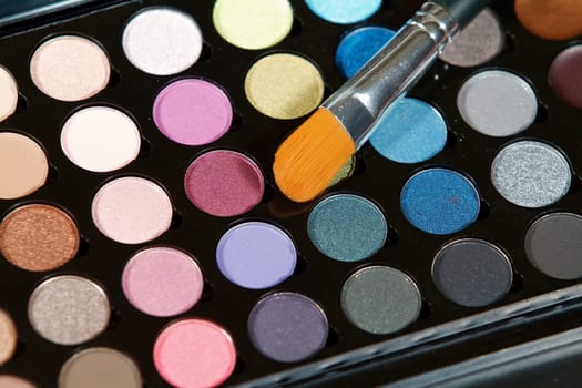 Make up colors and an application brush close up