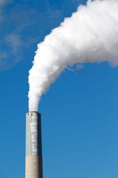 A tall smokestack spewing out dirty polluted smoke