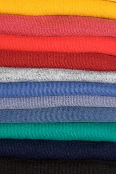 Stack of colored tee shirts on a shelf