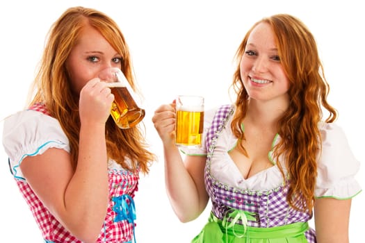 Two women in dirndl with beer and drinking on white background