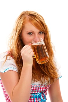 Young redhead woman in dirndl drinking beer on white background