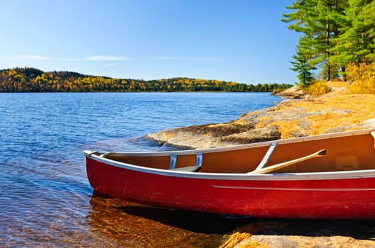 Red canoe on rocky shore of Lake of Two Rivers, Ontario, Canada