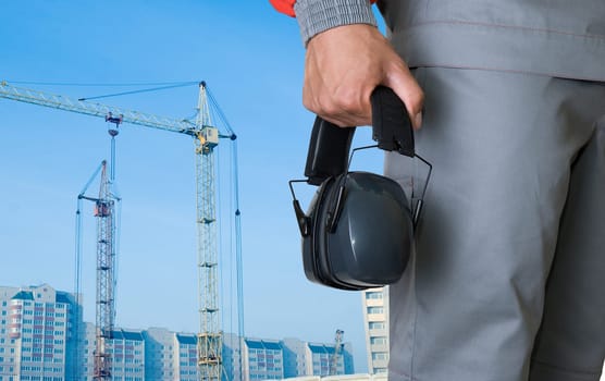 protective headphone at man hands on building background
