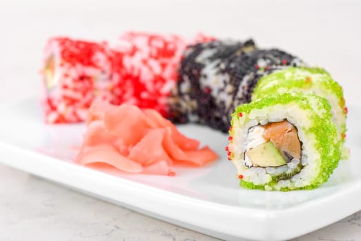 Sushi rolls made of fish avocado and different flying fish roe (tobiko caviar)