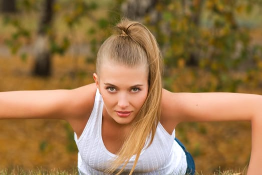 Beauty female doing push ups in the park