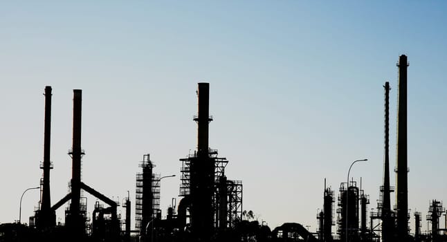 Silhouette of an oil refinery with pipes and chimneys