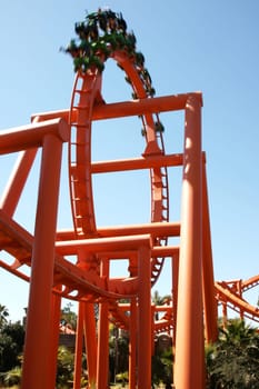Roller coaster in an amusement park with passengers blurred in speed