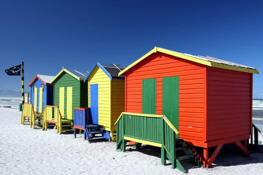 Brightly painted summer beach change rooms at the sea side in Cape Town