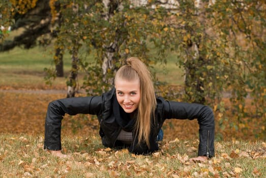 Beauty female doing push ups in the park