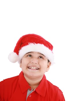 Cute little boy in Santa hat, looking up to copy space