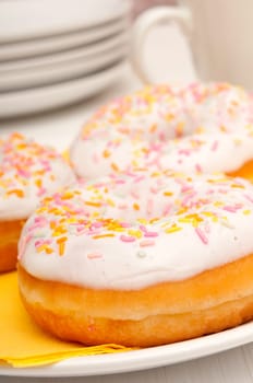 Donuts With Colorful Sprinkles, Plates and Mugs on Table
