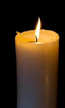 White candle is burning with a flame
