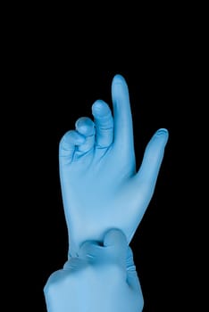 Blue gloves on a hand on a black background