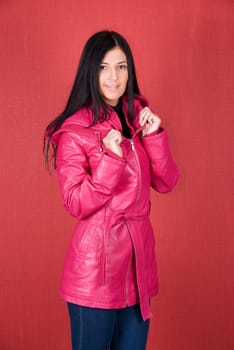 beautiful woman in a red jacket on a red background
