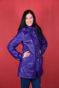beautiful woman in a red jacket on a red background