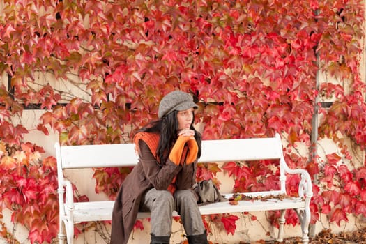 Autumn leaves park scenery young woman relax sitting on bench