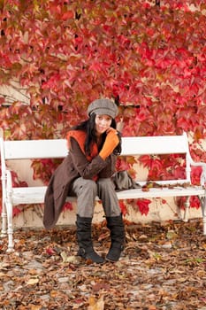 Autumn leaves park scenery young woman relax sitting on bench