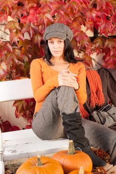 Autumn park young woman relax sitting on bench with pumpkins