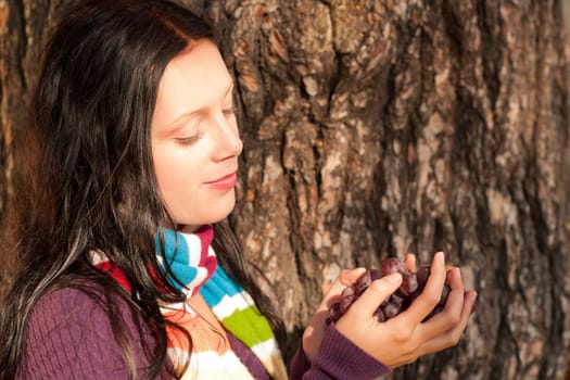 Winter outfit portrait of beautiful female model posing with grapes