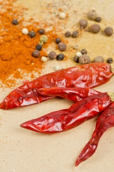 dried peppers and other kind of peppers spices on a brown background