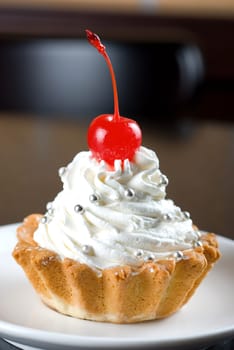 fresh baked cherry cupcake on a dark wooden background