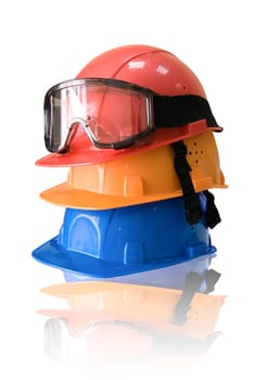 Many colored hardhats and goggles on white