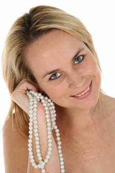 Portrait of a beautiful blond woman with lovely smile and holding pearls in her hand