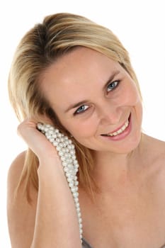Portrait of a beautiful blond woman with lovely smile and holding pearls in her hand