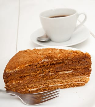 Traditional Honey Cake on Plate and White Cup of Coffee on Table