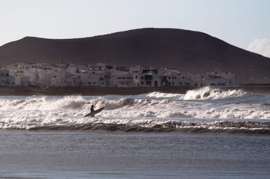 surfing the waves at sunset on Lanzarote, Canary Islands, Spain
